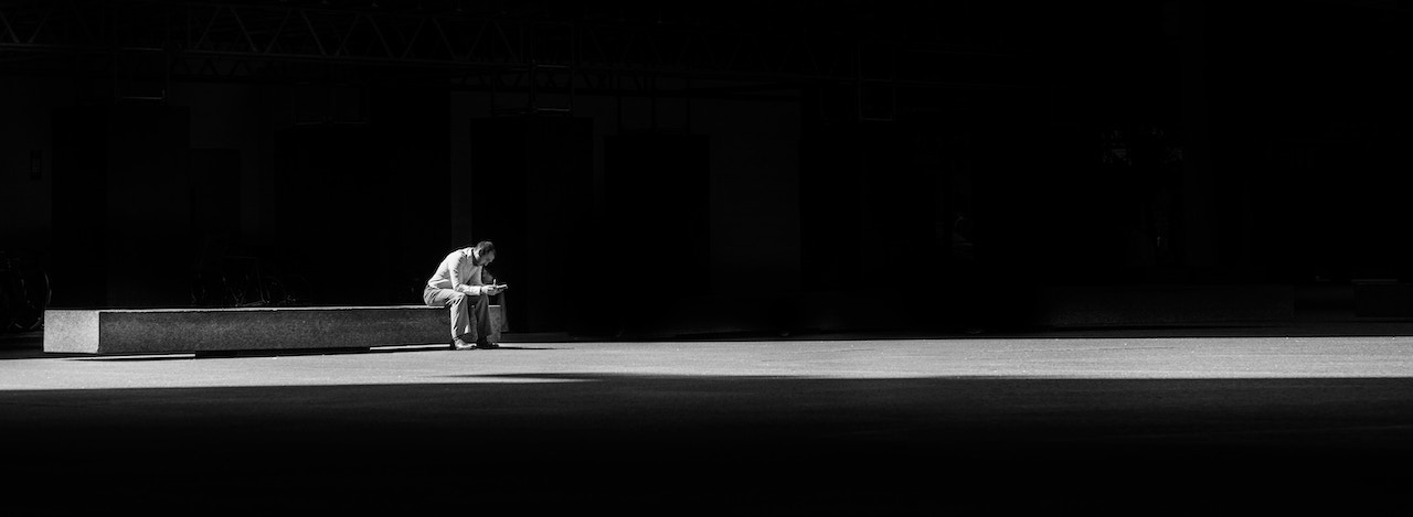 男子坐在混凝土长凳上的黑白照片